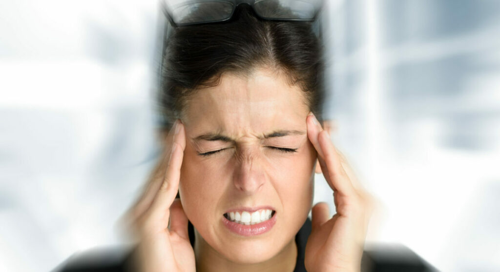 Businesswoman with intense stress and painful headache. Woman in job problems. Headache and EMF